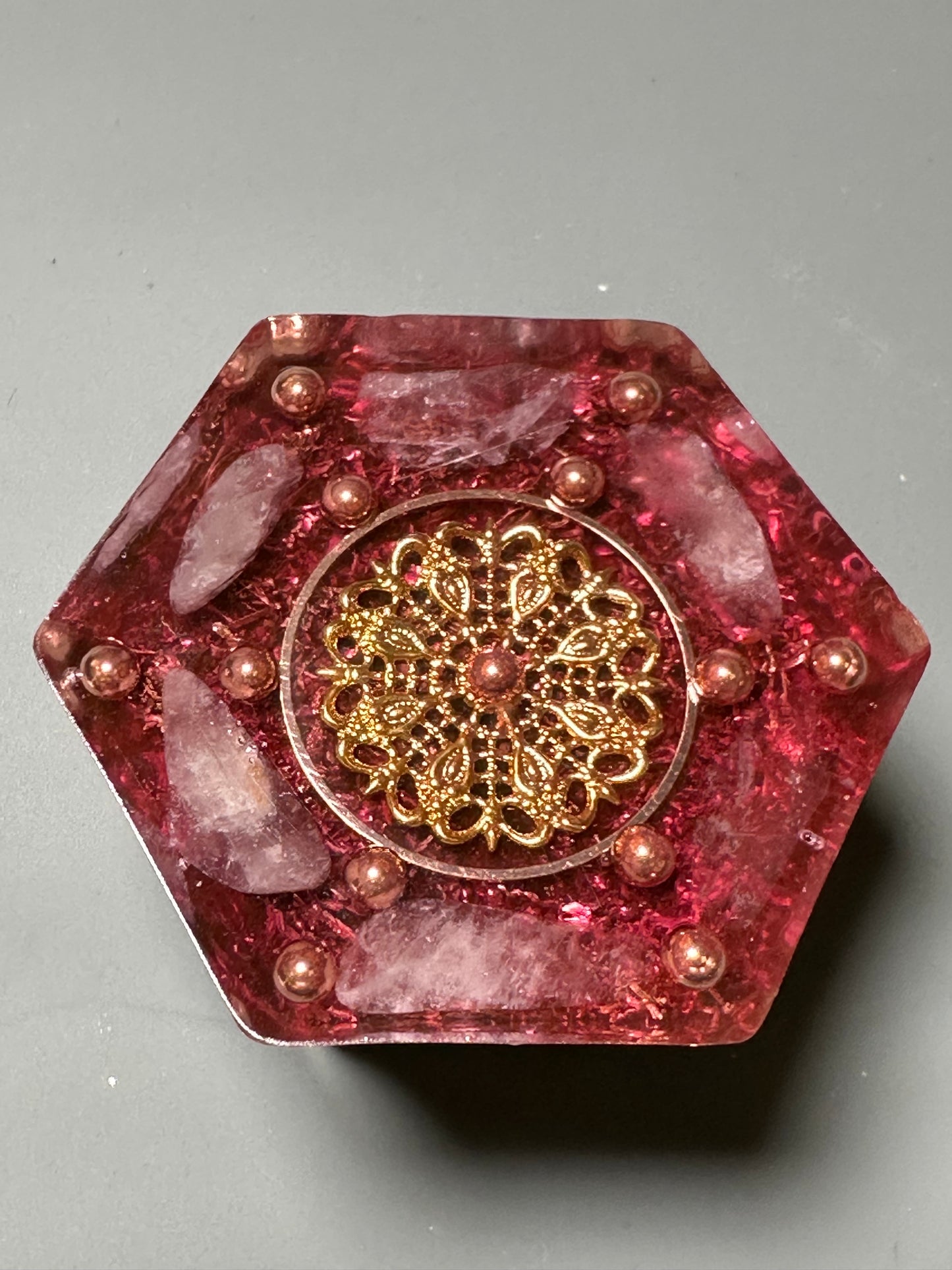 A hexagon shape orgonite is loaded with copper shavings