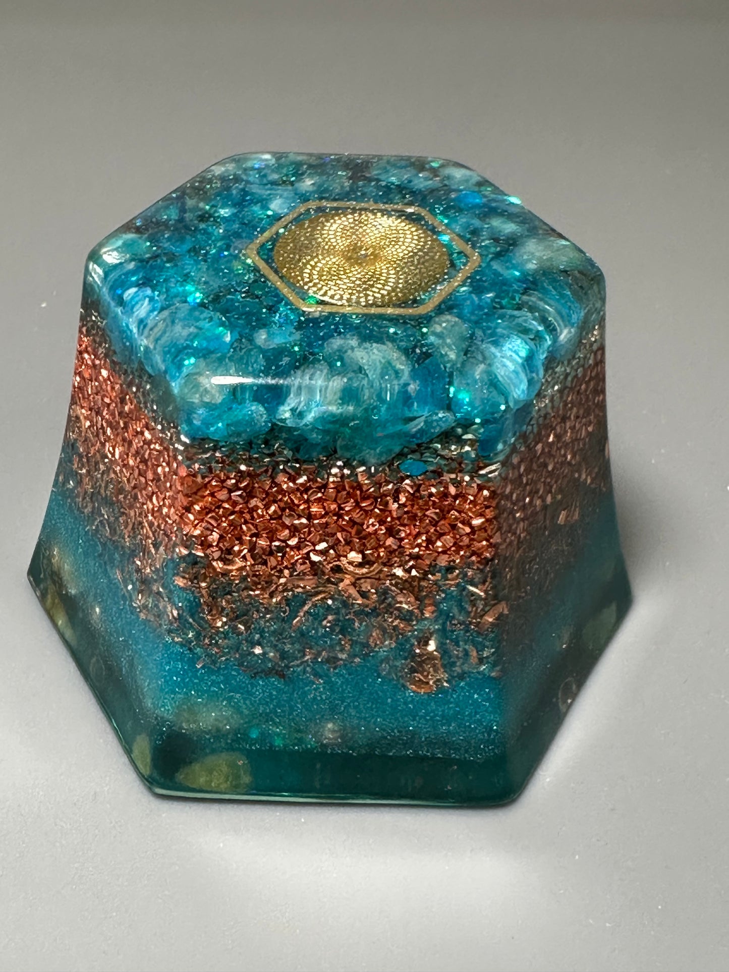 A hexagon shape orgonite is loaded with copper beads. (1 piece)